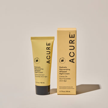 A yellow tube of ACURE Whipped Night Cream next to the box with the product details labeled ACURE